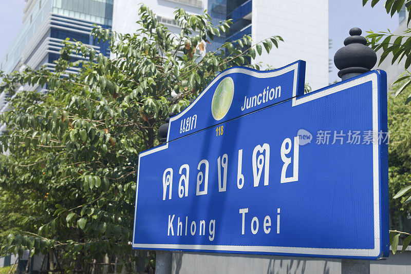 曼谷Rama IV路灌木丛前的蓝色路标区Khlong Toei